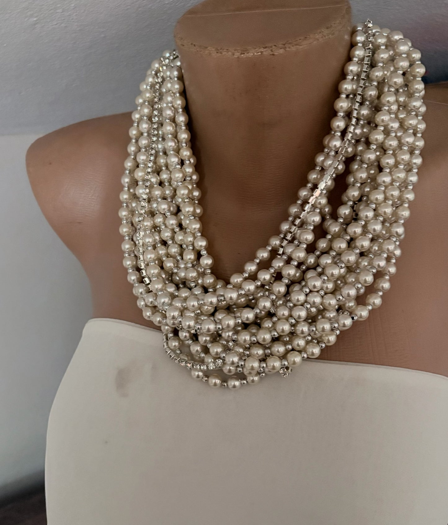 Semra Ascioglu multi-strand white pearl statement necklace with sparkling crystal accents on a mannequin